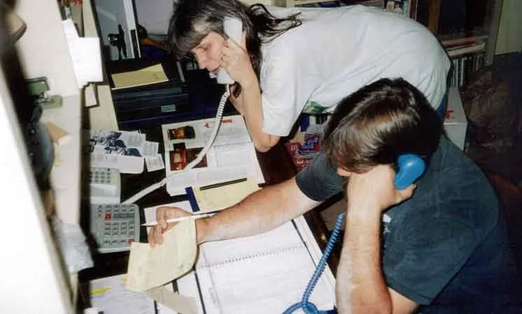 A man and a woman taking calls at a busy desk in Abbey Road Chimney Sweep's early years
