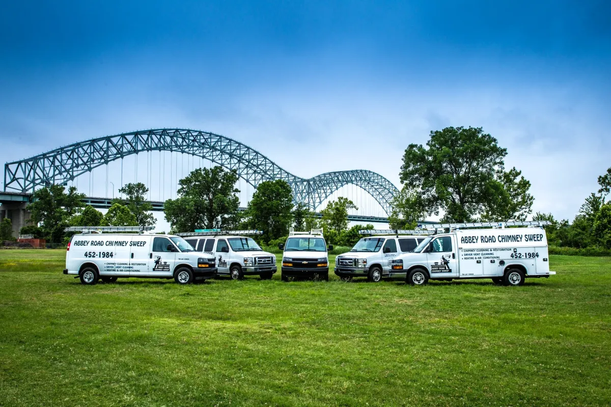 The Abbey Road Chimney Sweep fleet of service vans parked in front of the Memphis bridge