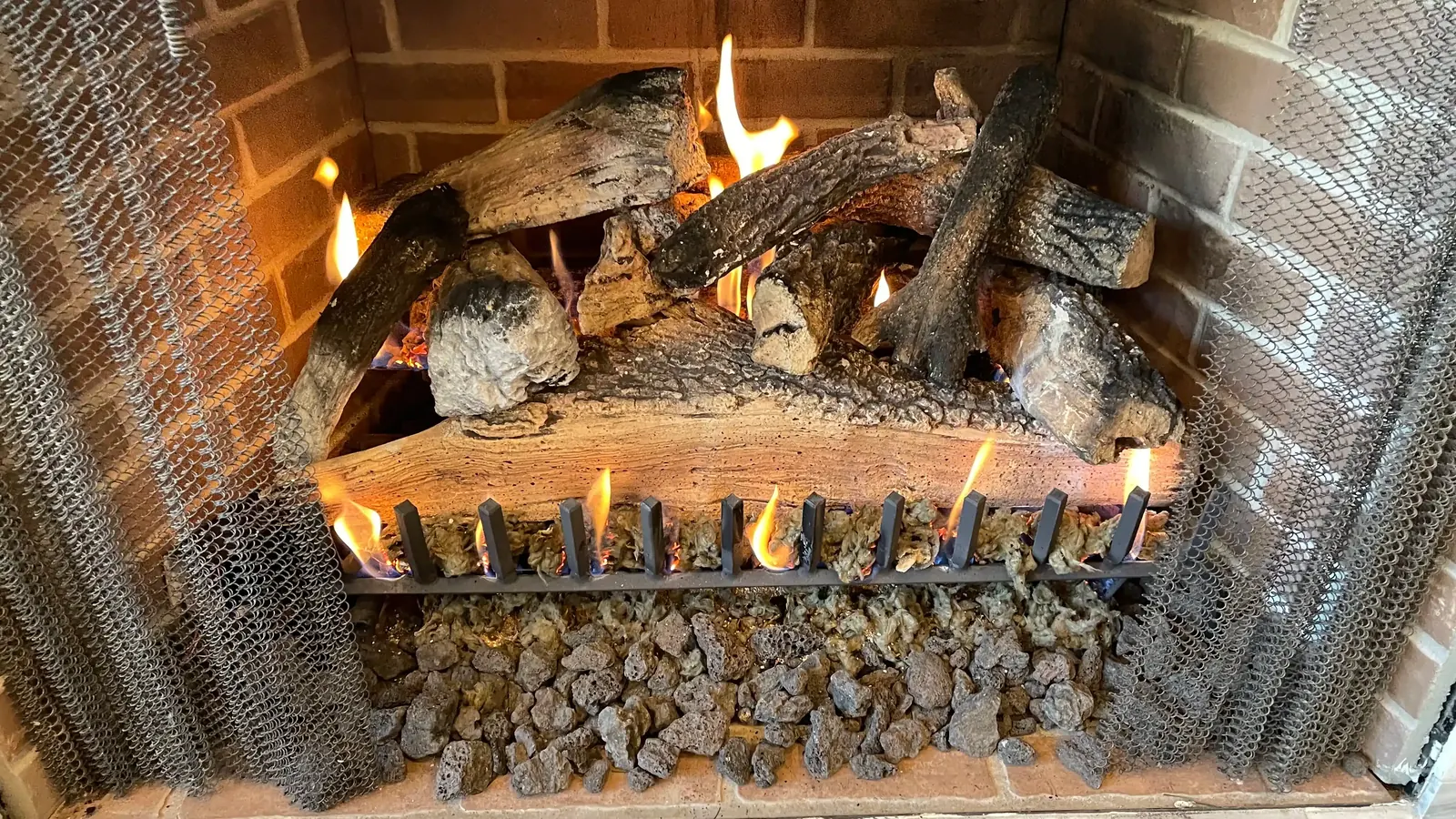 A gas log set burning in a masonry firebox